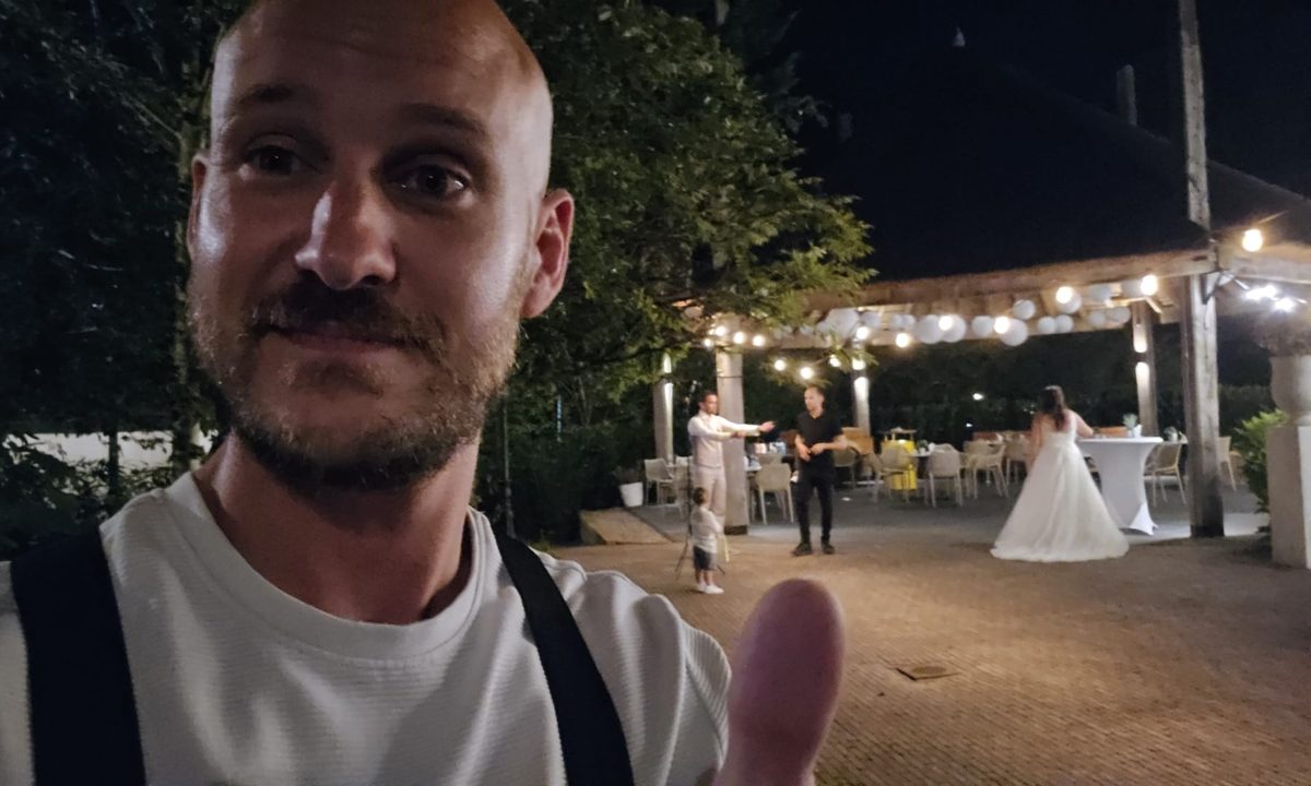 Bram tijdens een bruiloft, met het bruidspaar op de achtergrond